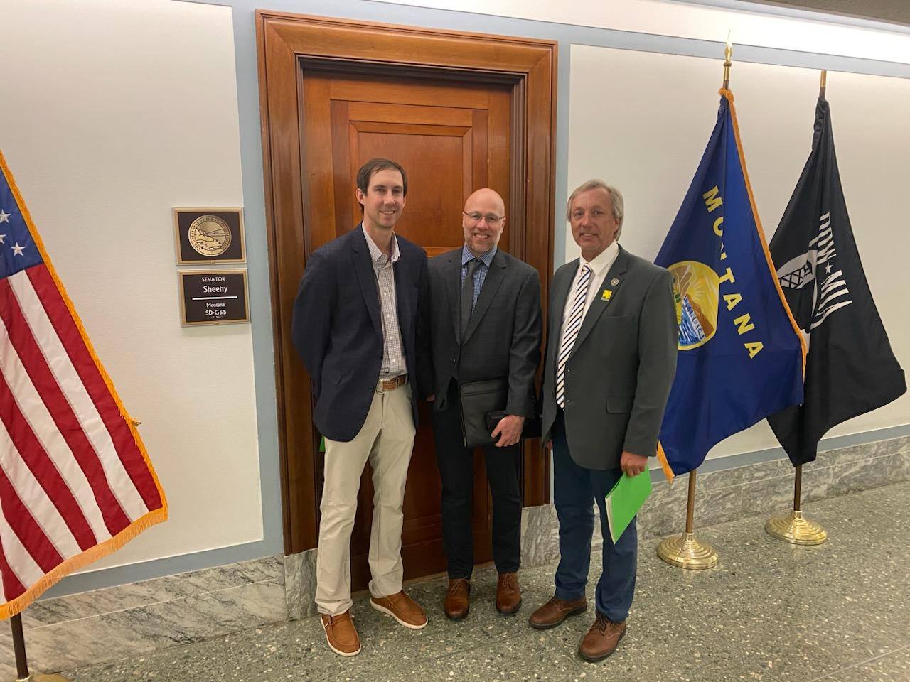 Three men at Senator Sheehy's office with Montana flags