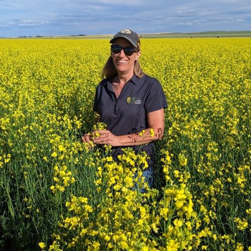 Woman standing in a vibrant yellow canola field